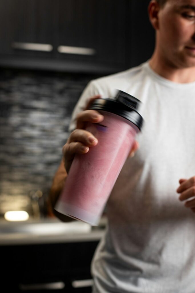a man holding a pink drink in his hand
