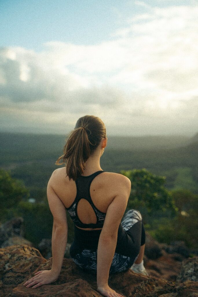 a woman sitting on top of a rock